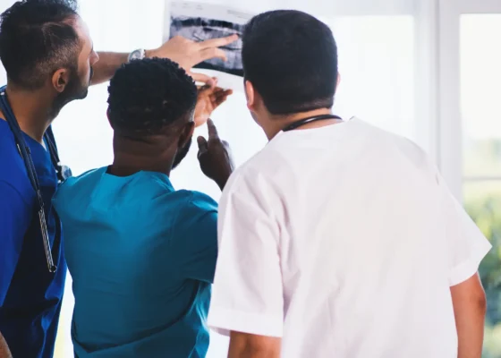 3 people who have a career in healthcare looking at an xray