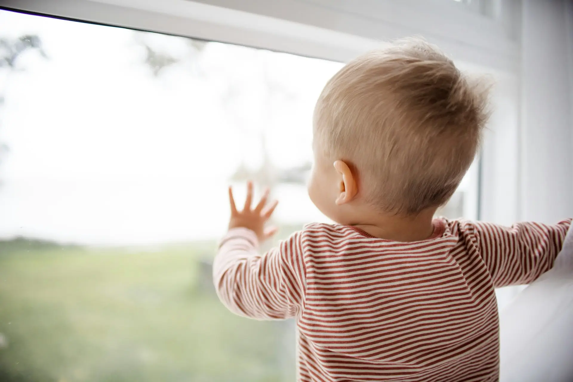 a young child looking out the window cared for by staffing recruited through a children's residential staffing agency
