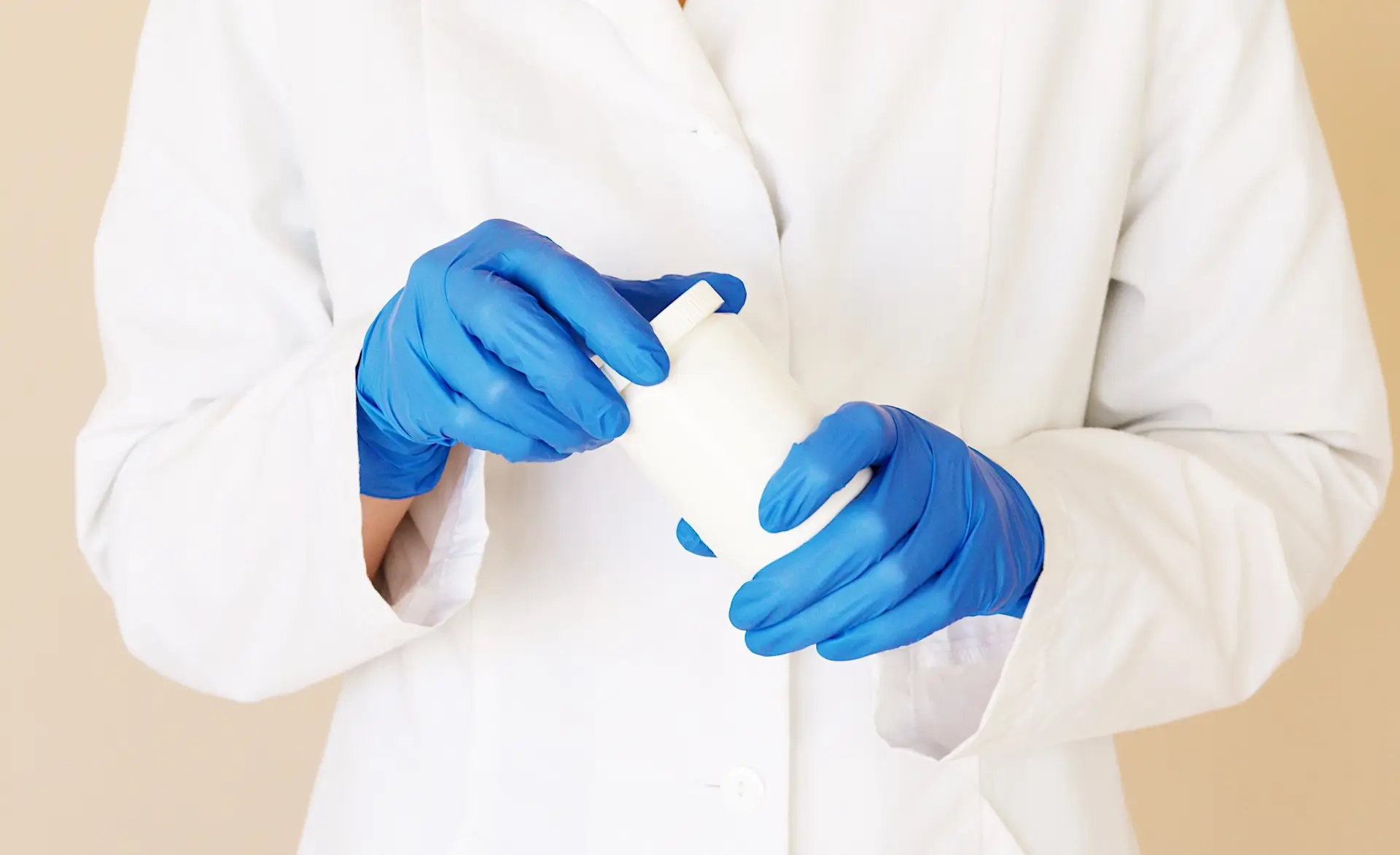 an image of someone wearing a white coat and blue healthcare gloves