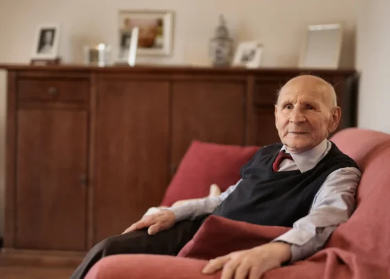 image of an elderly gentleman sitting in an armchair in a care home