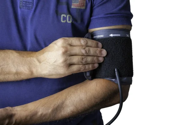 zoomed in image of an international healthcare assistant using a sphygmomanometer on themself