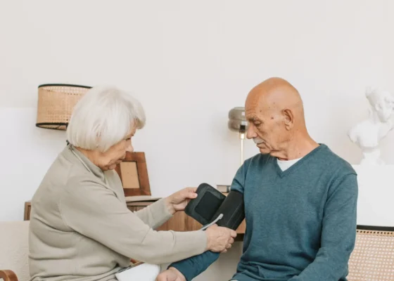 an image of an elderly woman checking the blood pressure of a man