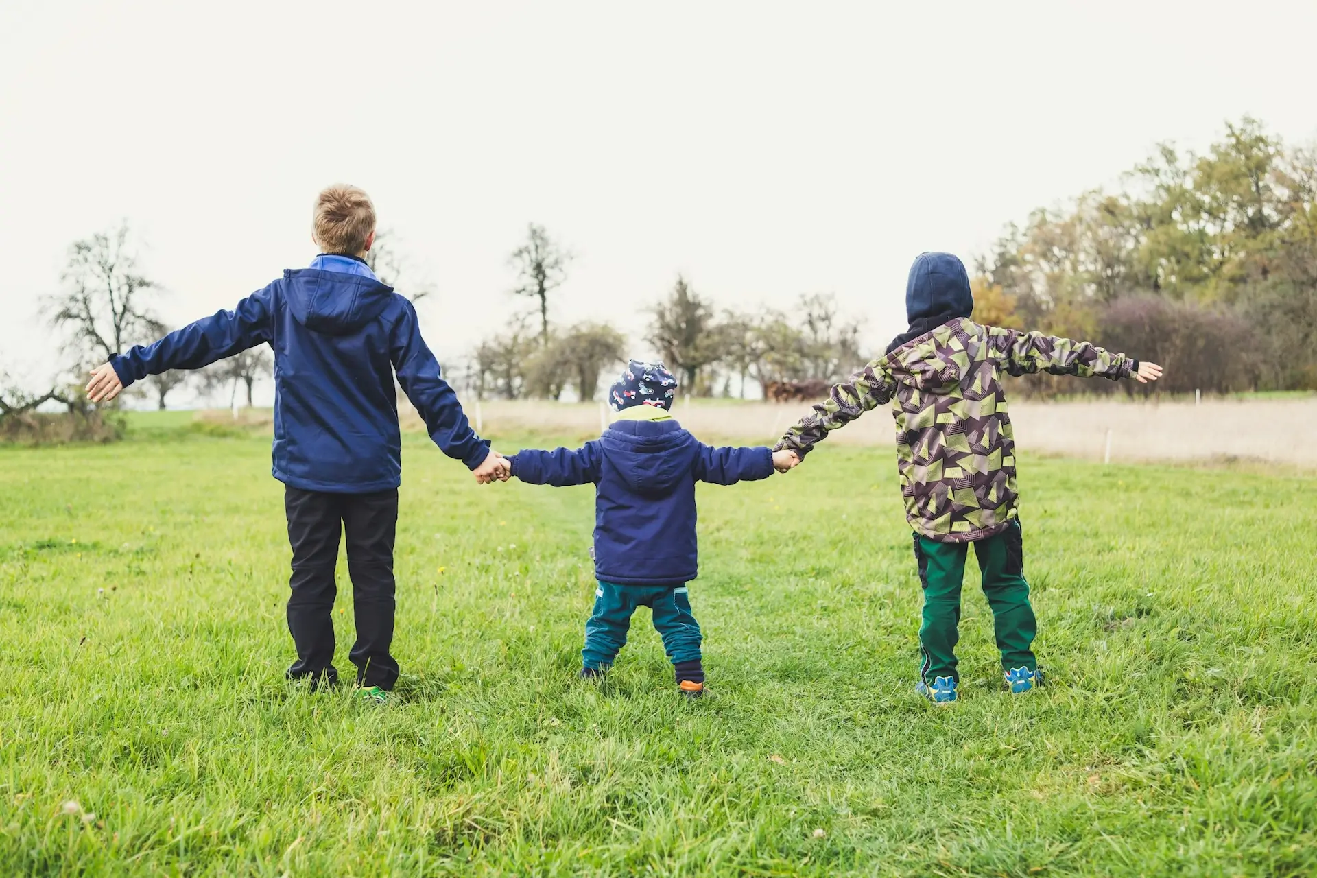 children playing a field, supported by residential children's staffing