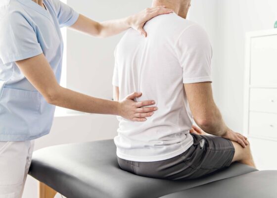 an image of a spinal cord complex care worker examining the spine of a patient