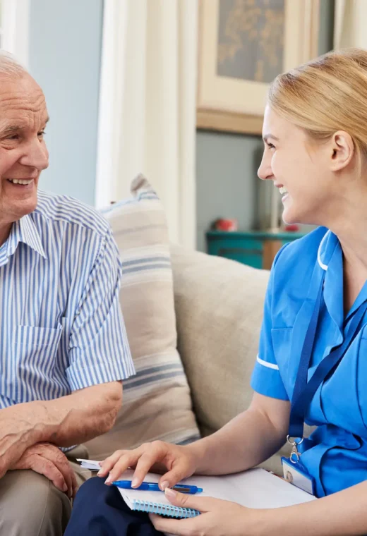 an image of a healthcare assistant talking to an older gentleman