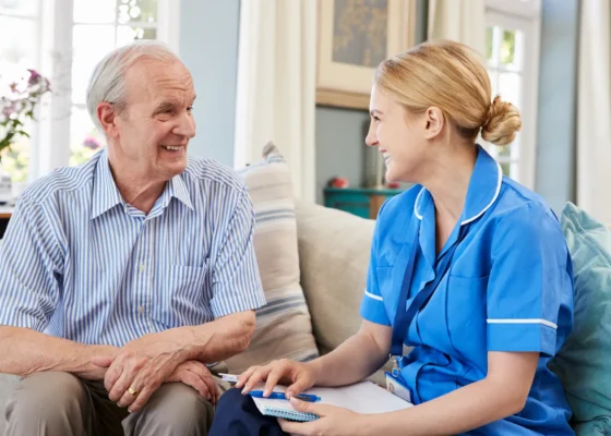 an image of a healthcare assistant talking to an older gentleman