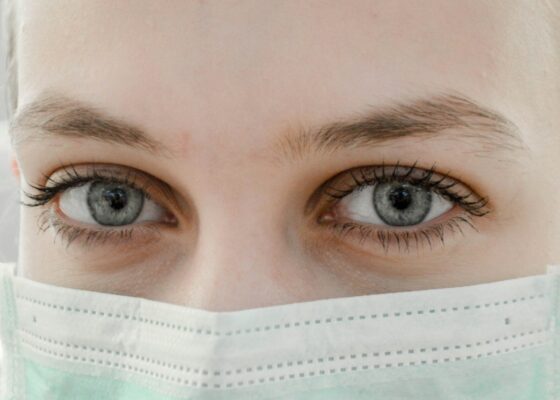 close up images of a nurses' eyes wearing a PPE mask, in an article discussing depression in nursing homes statistics