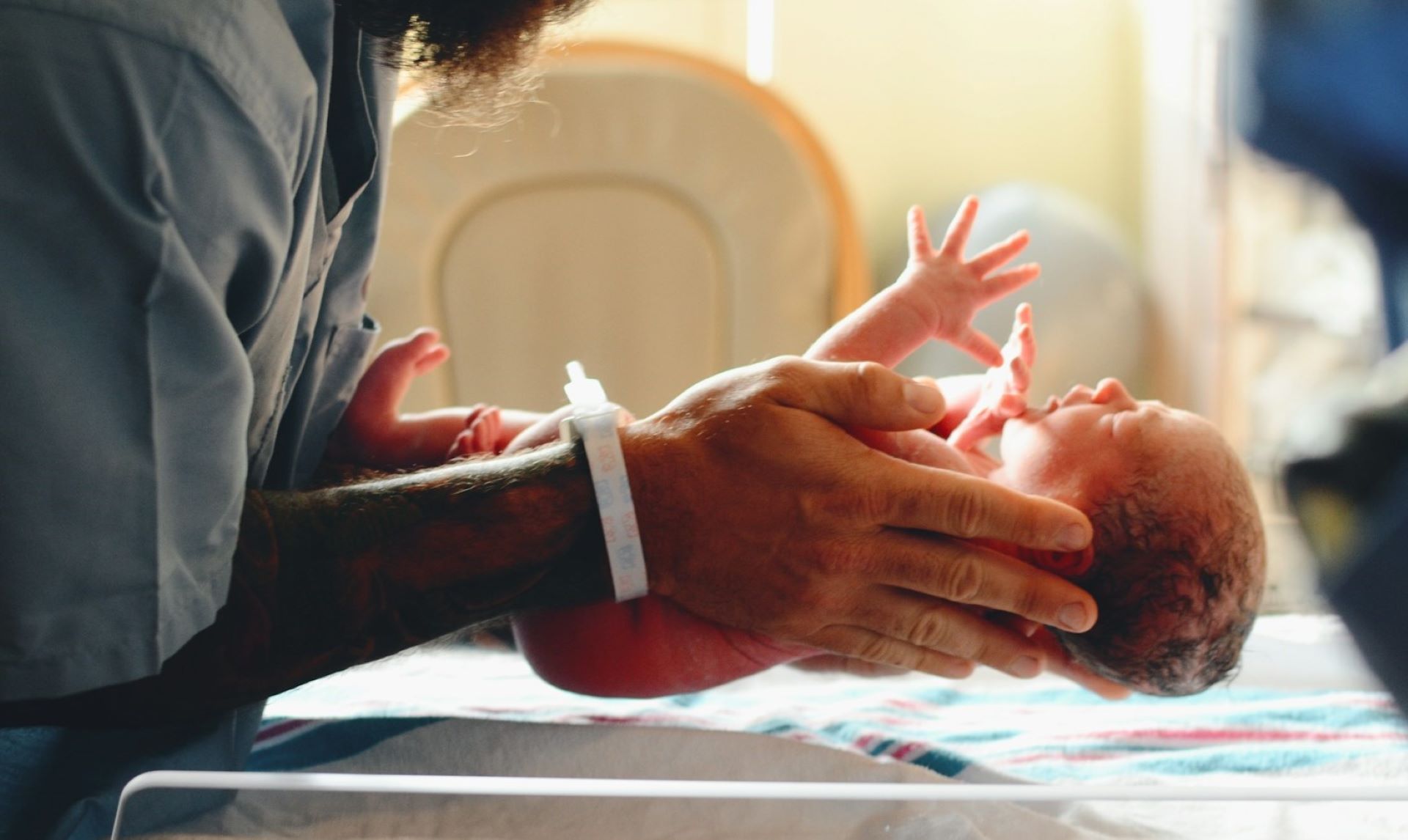 Midwife holding a new born baby representing career paths in midwifery