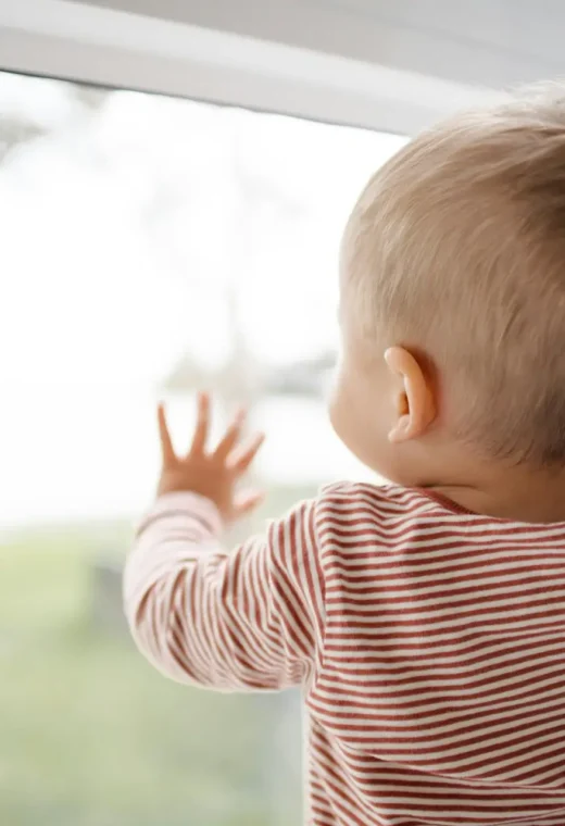 Child looking out of a window representing top qualities for working in children's services