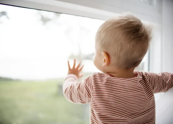 Child looking out of a window representing top qualities for working in children's services
